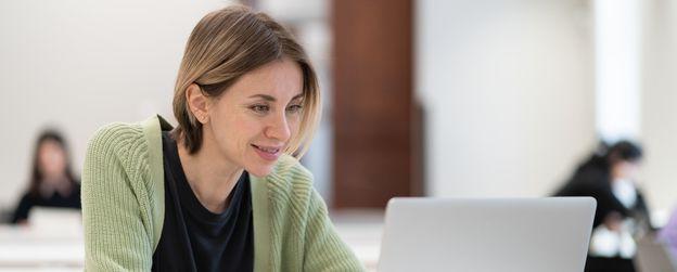 Woman looking at a laptop and smiling